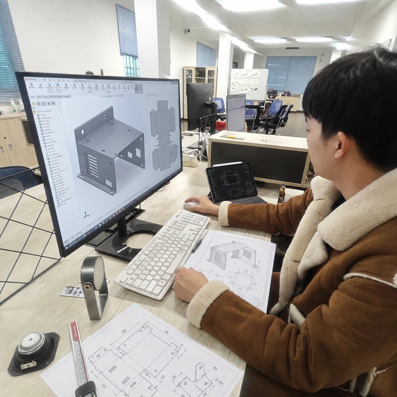 Sheet metal engineer reviewing CAD design and fabrication drawings for a custom sheet metal enclosure