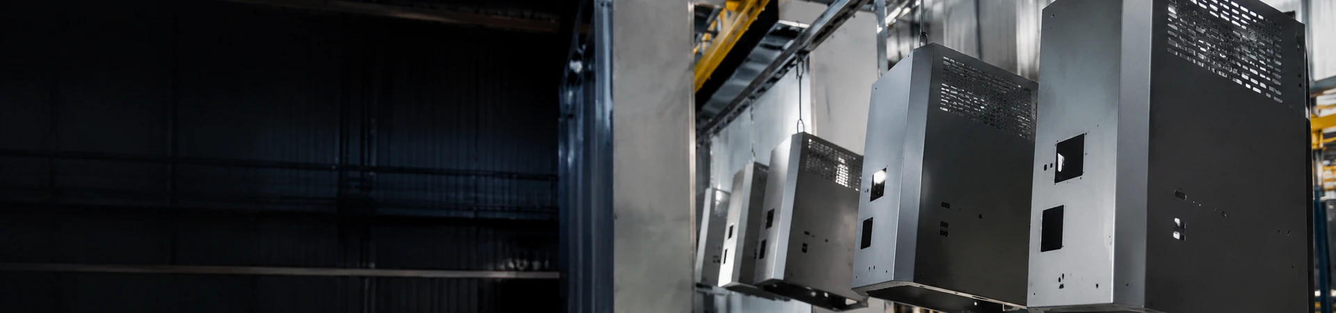 Sheet metal enclosures hanging on an industrial surface treatment and coating production line